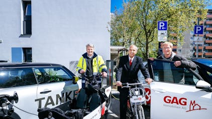 Jörn Hansen (TankE, links), Bernd Gräber (GAG, Mitte) und Frank Wendler (KVB, rechts)eröffnen den Mobilitäts-Hub mit Ladesäulen für E-Pkw, KVB-Rädern und GAG-Lastenradin der Kannebäckersiedlung in Humbold/Gremberg.