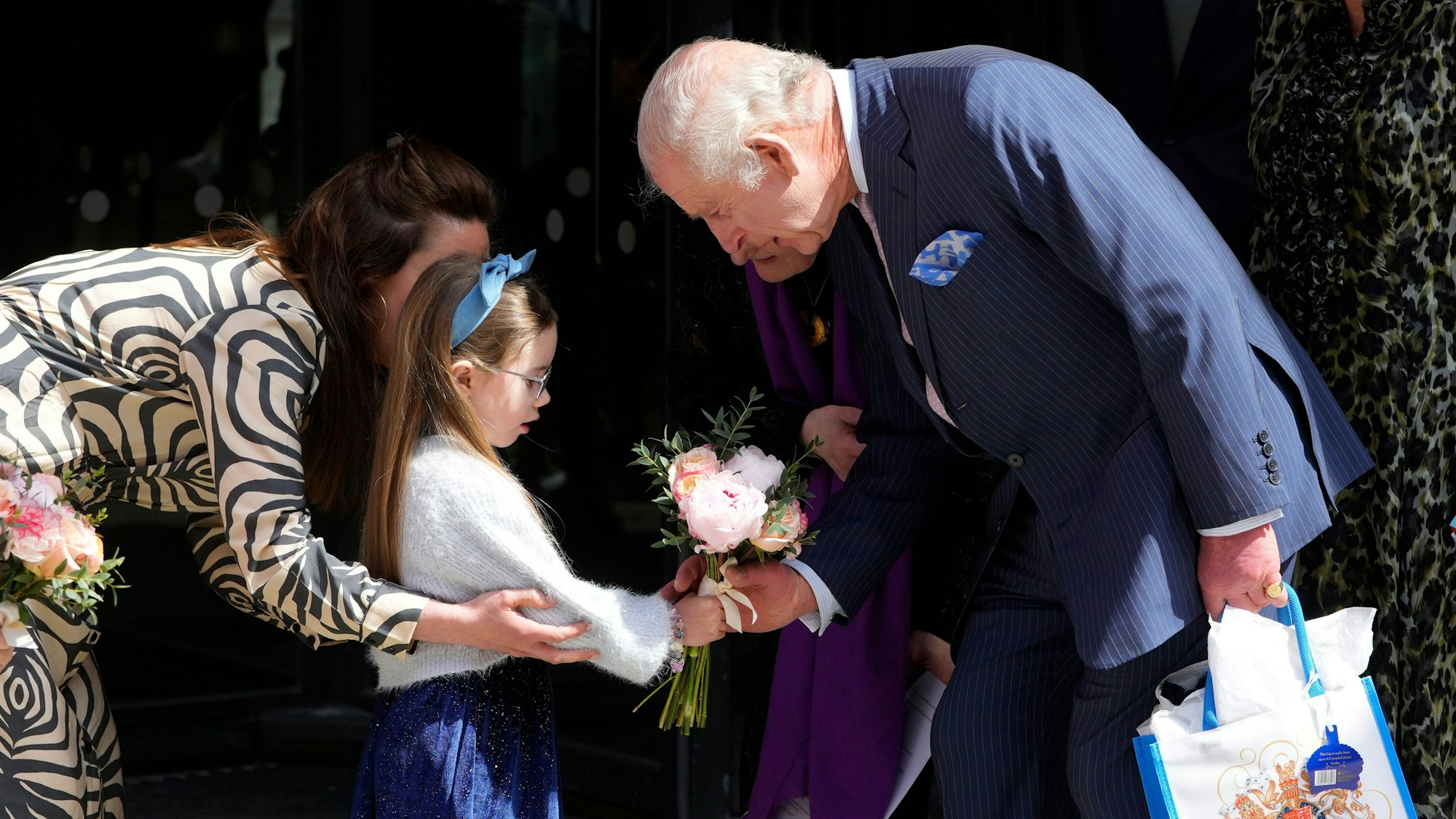 Der britische König Charles III. erhält Blumen, als er nach einem Besuch des Macmillan Cancer Centre des University College Hospital in London das Haus verlässt.