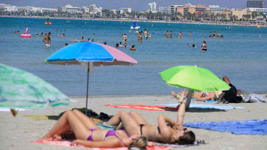 In einem beliebten Badeort drohen Geldstrafen für das Tragen von Bikinis und Badehosen außerhalb des Strandes. Das Symbolfoto von August 2023 zeigt einen Strand auf Mallorca – hier sind Bikinis noch gern gesehen.