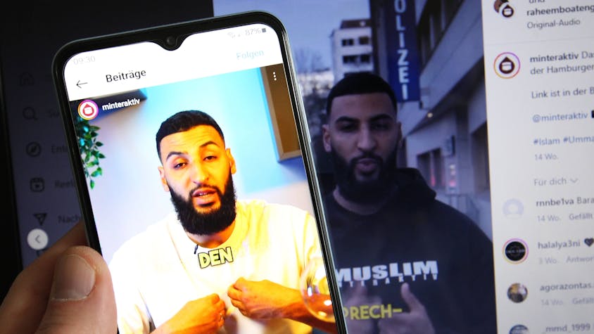Auf einem Smartphone wurde der TikTok-Kanal der Gruppierung Muslim Interaktiv aufgerufen. Im Bild ein Videobeitrag des Predigers Raheem Boateng. Dahinter ist auf einem Laptop der Instagram-Account der Gruppierung aufgerufen worden.
