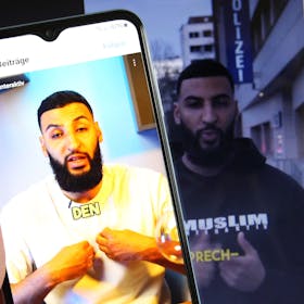 Auf einem Smartphone wurde der TikTok-Kanal der Gruppierung Muslim Interaktiv aufgerufen. Im Bild ein Videobeitrag des Predigers Raheem Boateng. Dahinter ist auf einem Laptop der Instagram-Account der Gruppierung aufgerufen worden.