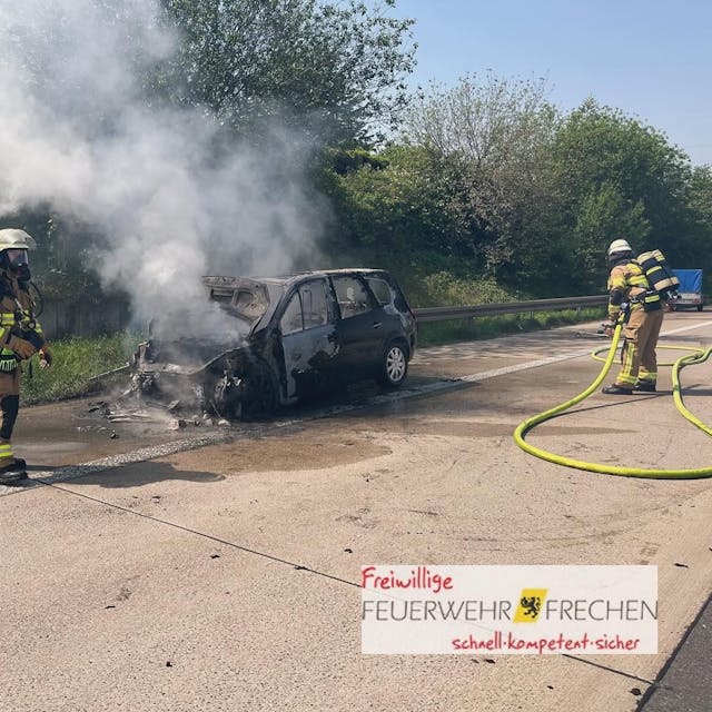 Zwei Feuerwehrleute löschen den brennenden Wagen auf der A4.