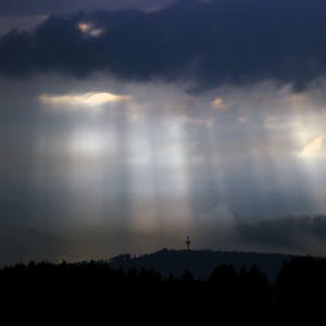 ARCHIV - 22.06.2021, Bayern, Rettenbach: Sonnenstrahlen dringen am Abend durch Wolkenlücken über dem Fernmeldeturm Weichberg. (zu dpa: «Erst Sonne, dann Gewitter: Unbeständiges Wetter zum Wochenende») Foto: Karl-Josef Hildenbrand/dpa +++ dpa-Bildfunk +++