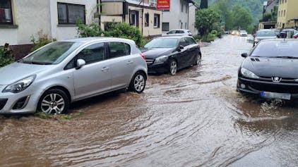 Autos fahren am 2. Mai im Schriesheimer Stadtteil Altenbach über eine überflutete Straße: Die Gemeinde Bisingen in Baden-Württemberg hat es besonders heftig getroffen.