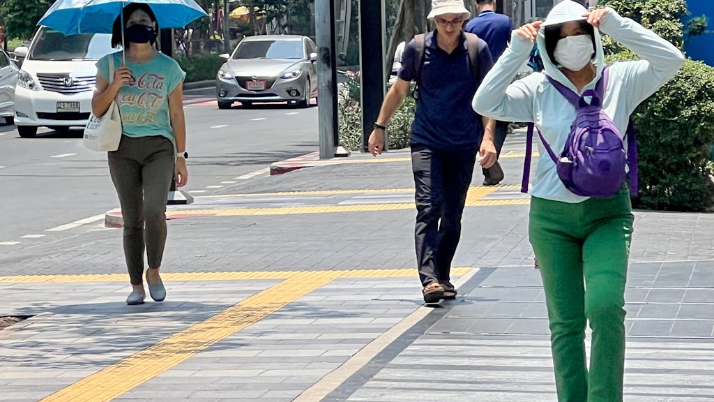 Menschen auf der Silom Road in Bangkok versuchen, sich vor der Hitze zu schützen. Eine extreme Hitzewelle hat Thailand und andere Länder Asiens seit Wochen fest im Griff.