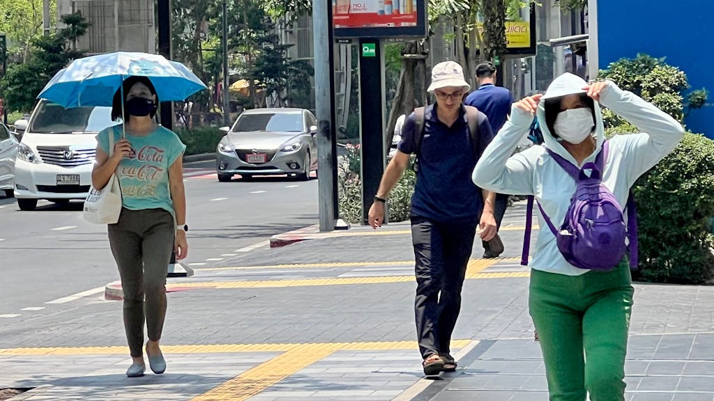 Menschen auf der Silom Road in Bangkok versuchen, sich vor der Hitze zu schützen. Eine extreme Hitzewelle hat Thailand und andere Länder Asiens seit Wochen fest im Griff.