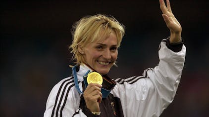 Heike Drechsler präsentiert stolz ihre Goldmedaille.