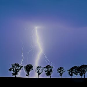 Ein Blitz eines Gewitters erhellt den Nachthimmel.