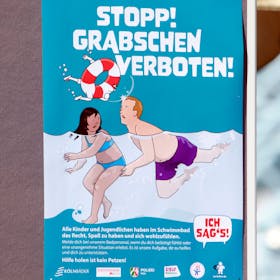Eines von sechs Kampagnen-Plakaten gegen sexuelle Belästigung in Kölns Schwimmbädern zeigt einen Mann, der einem Mädchen unter Wasser an den Po greift, darüber steht in großen Buchstaben: „Stopp Grabschen verboten!“
