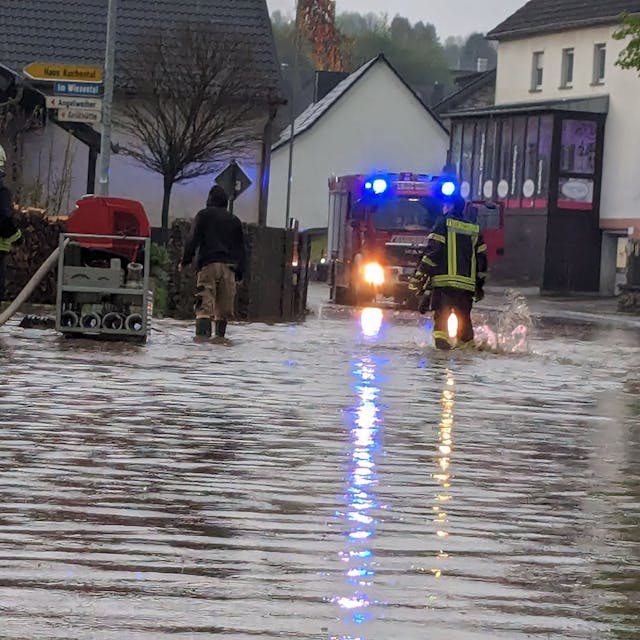 Das Bild zeigt eine überflutete Straße in Schmidtheim. Die Feuerwehr pumpt das Wasser ab.