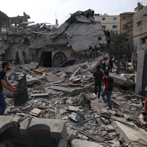 Menschen stehen inmitten der Trümmer eines zerstörten Hauses in der Stadt Deir el-Balah im Zentrum des Gazastreifens.