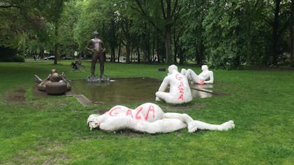 Statuen bei einem Teich umgeben von Bäumen sind beschmiert worden.