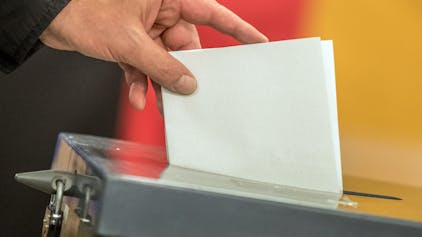 Ein Wähler wirft seinen Stimmzettel in eine Wahlurne.