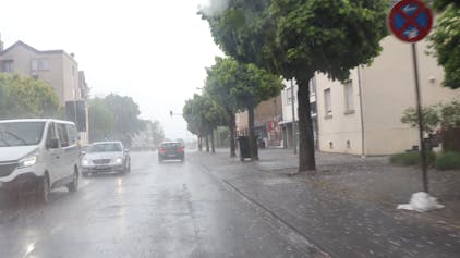 Eine Straße, Regen, Autos und Hagelkörner.