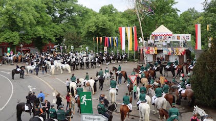 Zu sehen sind viele Reiter in Uniformen auf einem Platz in Gymnich.