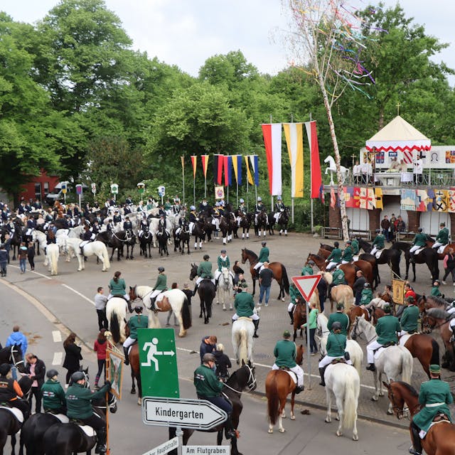 Zu sehen sind viele Reiter in Uniformen auf einem Platz in Gymnich.