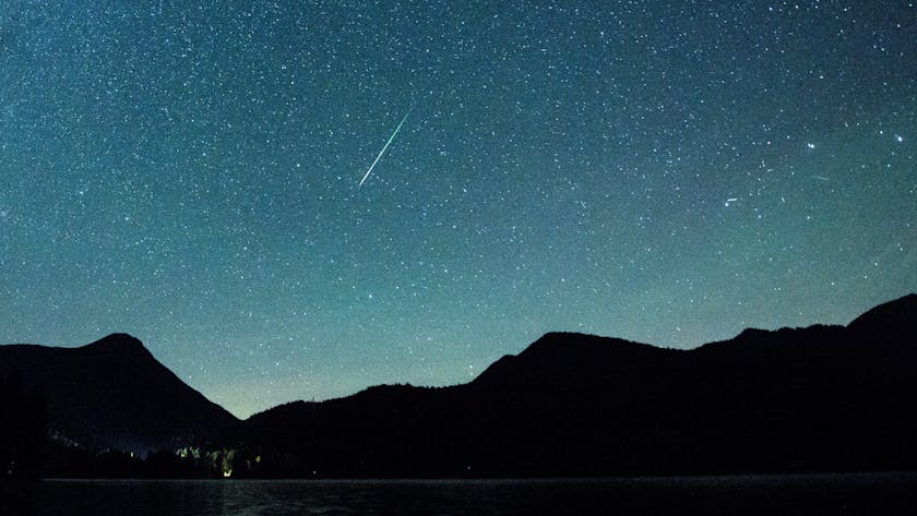Bayern, Einsiedl: Eine Sternschnuppe leuchtet neben der Milchstraße am Himmel über dem Walchensee. (Archivbild)