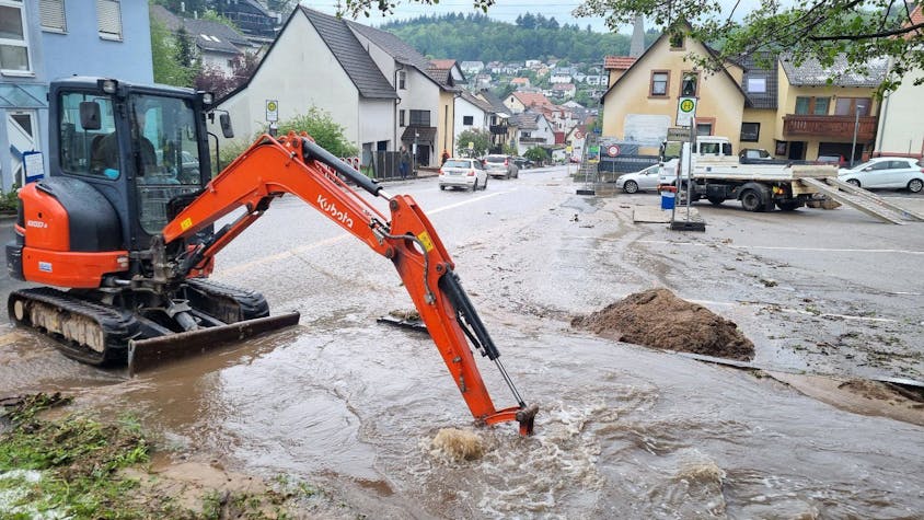 Ein Bagger versucht im baden-württembergischen Schriesheim einen übergelaufenen Bach freizuschaufeln. Schwere Unwetter haben in weiten Teilen Deutschlands Überflutungen, Hochwasser und teilweise sogar Katastrophenalarm ausgelöst.