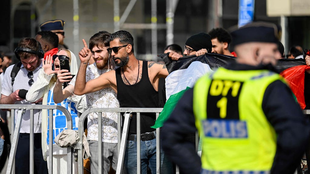 Gegendemonstrantinnen und -demonstranten sowie Polizeikräfte sind am 3. Mai 2024 auf dem Gustav-Adolfs-Torg-Platz in Malmö zu sehen. Anlass ist eine öffentliche Versammlung, bei der ein Tag vor Beginn des ESC ein Koran verbrannt werden soll.