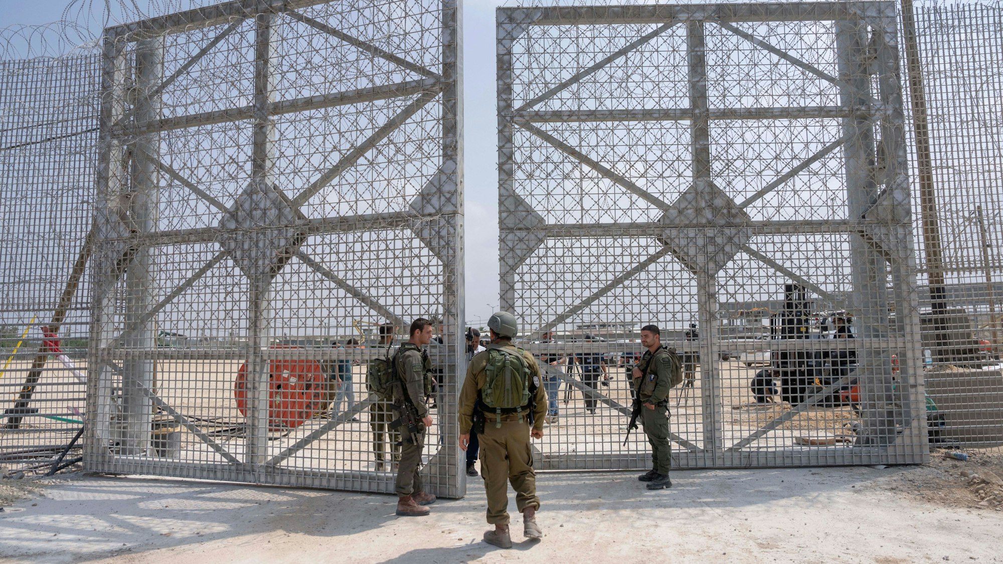 01.05.2024, Palästinensische Gebiete, Grenzübergang Erez: Israelische Soldaten versammeln sich in der Nähe eines Tores, um einen Kontrollbereich für Lastwagen mit humanitären Hilfsgütern für den Gazastreifen zu passieren. Foto: Ohad Zwigenberg/AP/dpa +++ dpa-Bildfunk +++