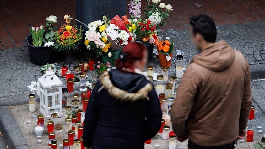 Kerzen stehen am Tatort des tödlichen Angriffs in der Paderborner Innenstadt vor einem Kiosk, immer wieder kommen Menschen vorbei und trauern. Zwei Tatverdächtige haben sich inzwischen gestellt.