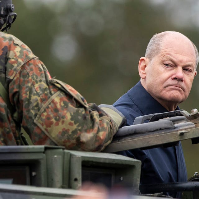 Bundeskanzler Olaf Scholz (SPD) fährt auf einem gepanzerten Militärfahrzeug.