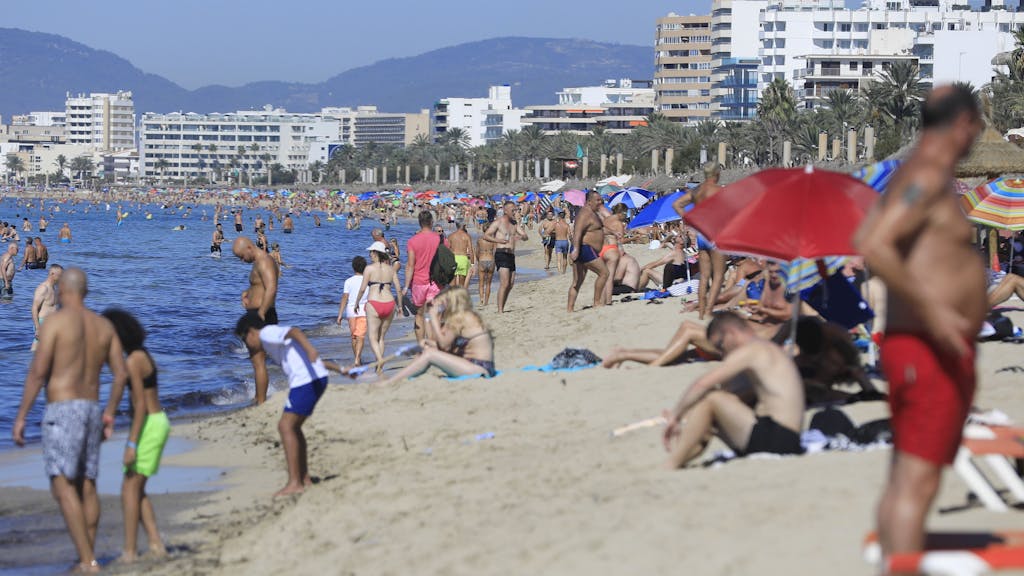 Urlauberinnen und Urlauber am Strand von Mallorca.