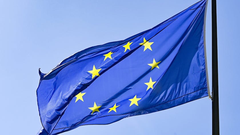 Eine Europaflagge weht vor blauem Himmel.