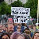 Ein Demonstrant hält bei einer Solidaritätskundgebung in Berlin ein Plakat mit der Aufschrift „Dresden Schläger – Höckes willige Helfer“. Sowohl in der Hauptstadt als auch in Dresden versammelten sich am Sonntag Menschen aus Solidarität mit dem angegriffenen SPD-Politiker Matthias Ecke und einem Wahlhelfer.