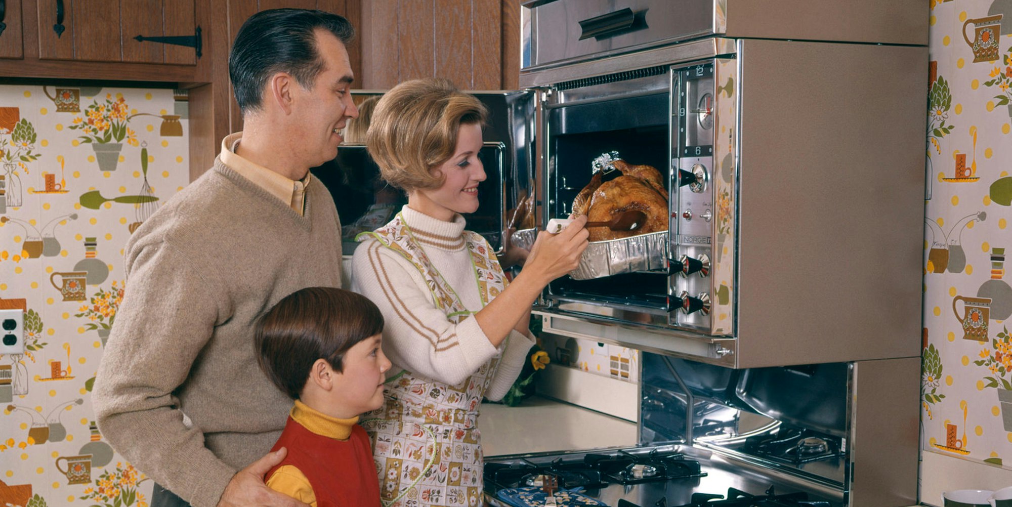 In den 60er Jahren holt eine Hausfrau einen Braten aus dem Ofen.