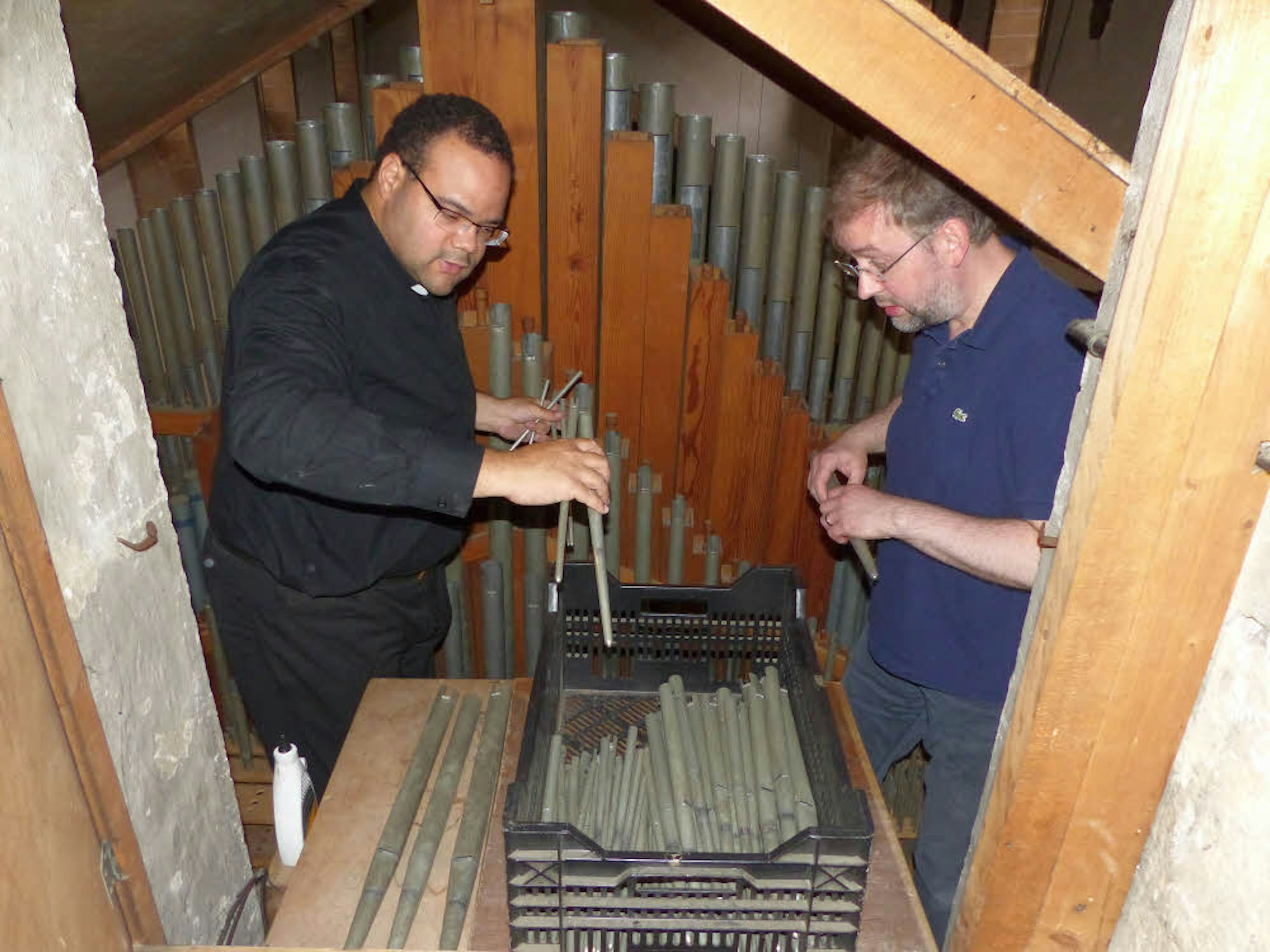 Die alte Orgel hat 54 Jahre lang ihren Dienst getan, war zuletzt aber in einem äußerst desolaten Zustand. Pfarrer Tobias Zöller (l.) und Organist Adam Lenart halfen mit, die alten Orgelpfeifen auszubauen.