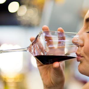 Eine Frau trinkt ein Glas Rotwein