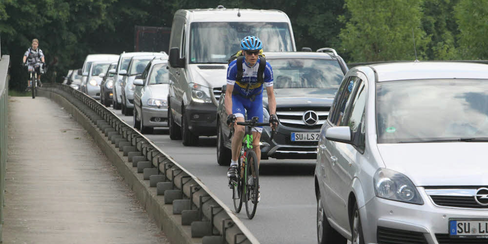 Der Radsportler zwischen vielen Autos auf dem Nachhauseweg auf der Allner Brücke über die Sieg