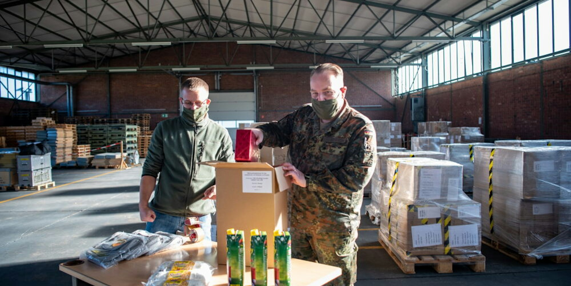 Stollen, Punsch und Geschenke verpackten Marco Groß (links) und Oberstleutnant Dirk Hagenbach im Materiallager in Mechernich. 4821 Päckchen wurden hier insgesamt gepackt, eins für jeden Soldaten im Auslandseinsatz.