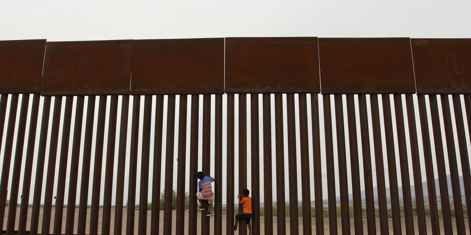 Kinder klettern an der Grenzanlage zwischen Mexiko und den Vereinigten Staaten von Amerika.