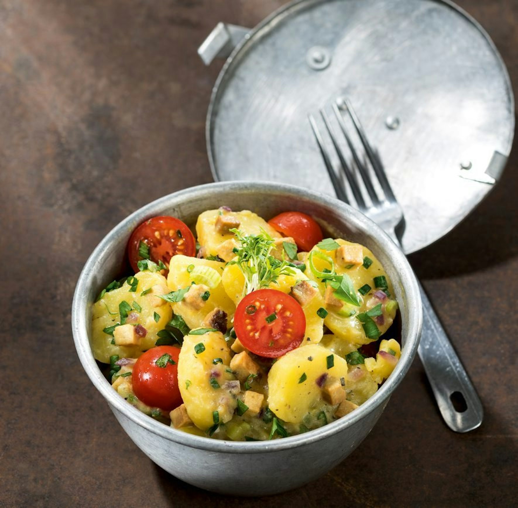 Ein Kartoffelsalat für vegane Feinschmecker bekommt durch Räuchertofu, Kirschtomaten und Senfdressing eine besondere Note.
