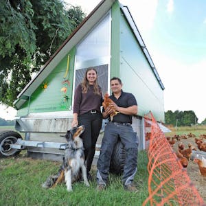 Lena Jörgens und Florian Hugo mit Hund Fred vor ihrem Hühnermobil. In einigen Tagen geht es auf der Weide ein paar Meter Weiter.