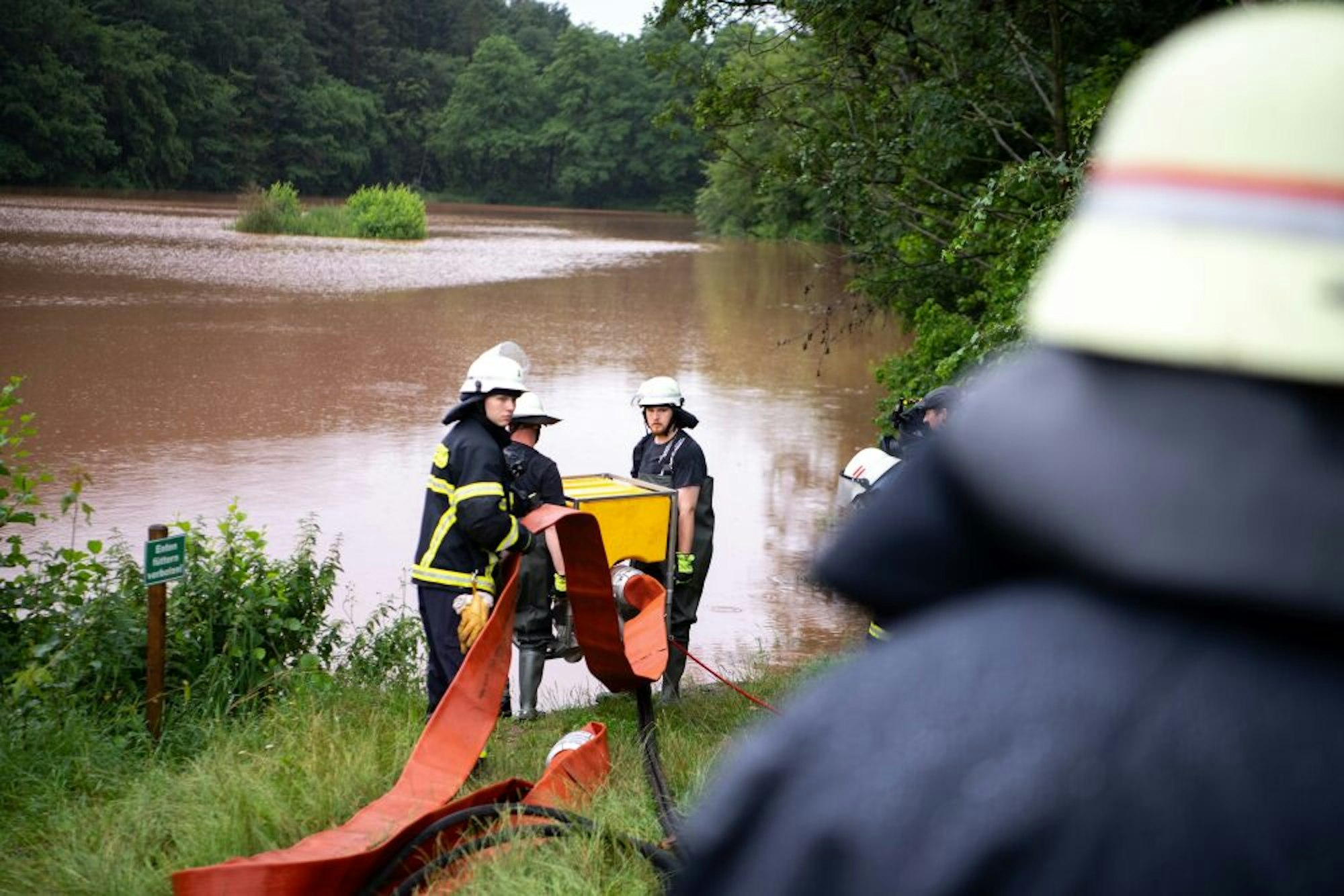 Im Kommerner Mühlensee bringen Feuerwehrleute eine Schwimmpumpe in Stellung. Mit ihr soll massiv Wasser abgepumpt werden.