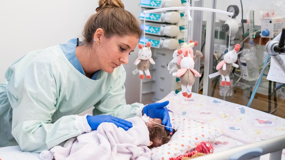 Eine Kinderkrankenpflegerin versorgt ein Baby im Krankenhaus.