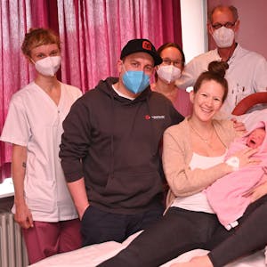 Theo bei seinen Eltern Yvette und Marvin Heinzelmann (v.) und dem Team der VPH-Geburtsstation. Auch Chefarzt Simeon Korth (re.hi.) freut sich mit.