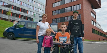 Die alleinerziehende Mutter Lisa Osenberg mit ihren Kindern Sveja (8), dem schwerst kranken Nico (16) und Felix (18). Beide Brüder wollen das Berufskolleg (im Hintergrund) besuchen.