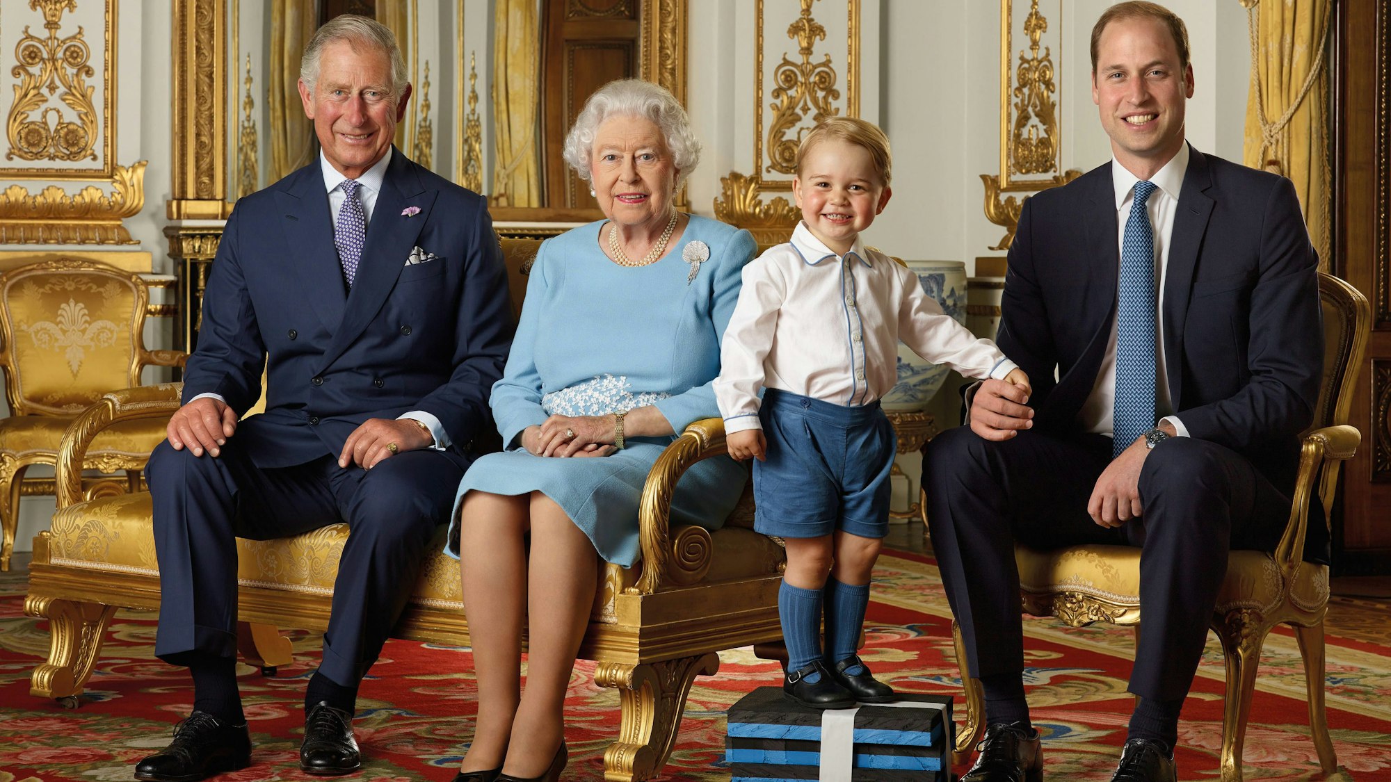 König Charles III, die 2022 verstorbene Königin Elizabeth II, Prinz George und Prinz William, der Thronfolger.