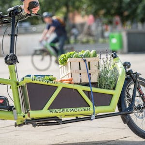 Ein Radfahrer transportiert mit seinem Elektro-Lastenrad Gemüsekisten. (Symbolbild)