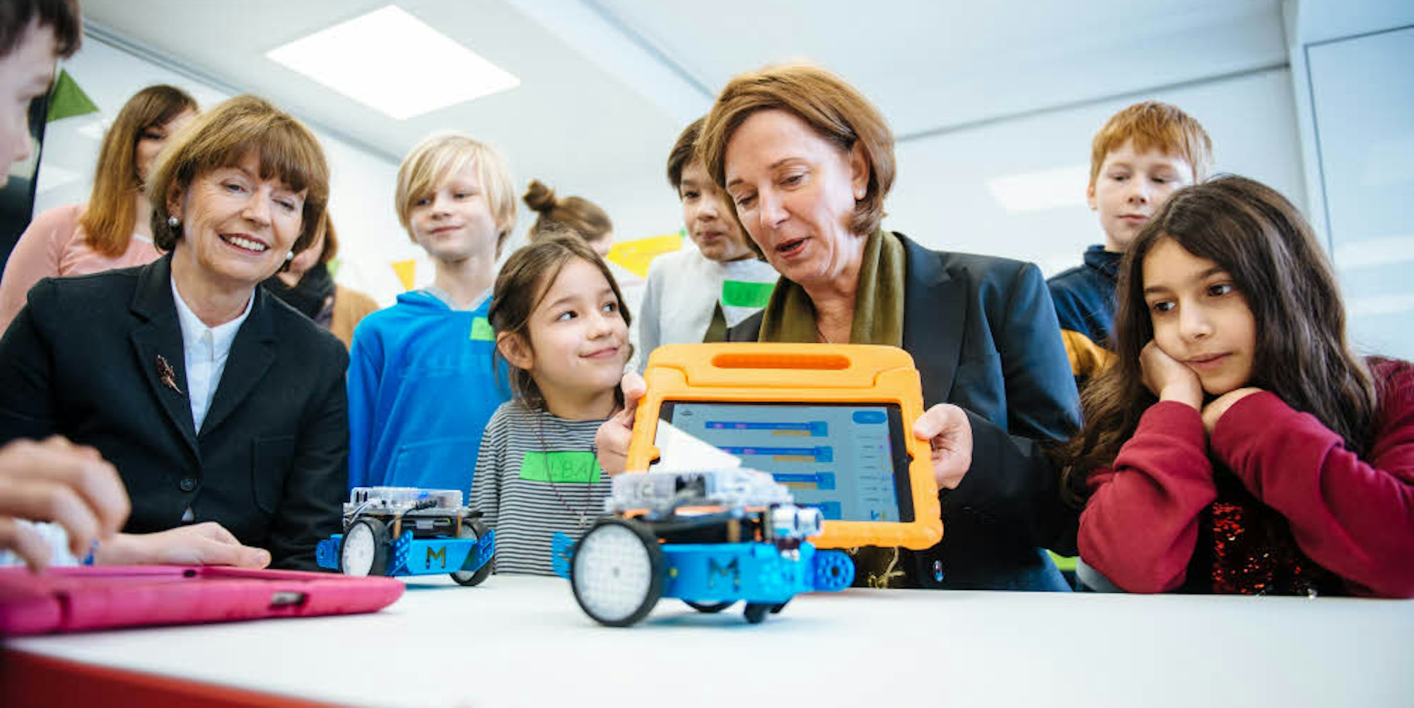 So geht das: NRW-Schulministerin Yvonne Gebauer (Mitte) und OB Henriette Reker lassen sich von Alba und Lisa vorführen, wie der Roboter bewegt wird.