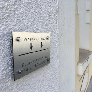Eine Markierung zeigt, wie hoch das Wasser vor einem Jahr in der Wilhelmstraße in Euskirchen stand.