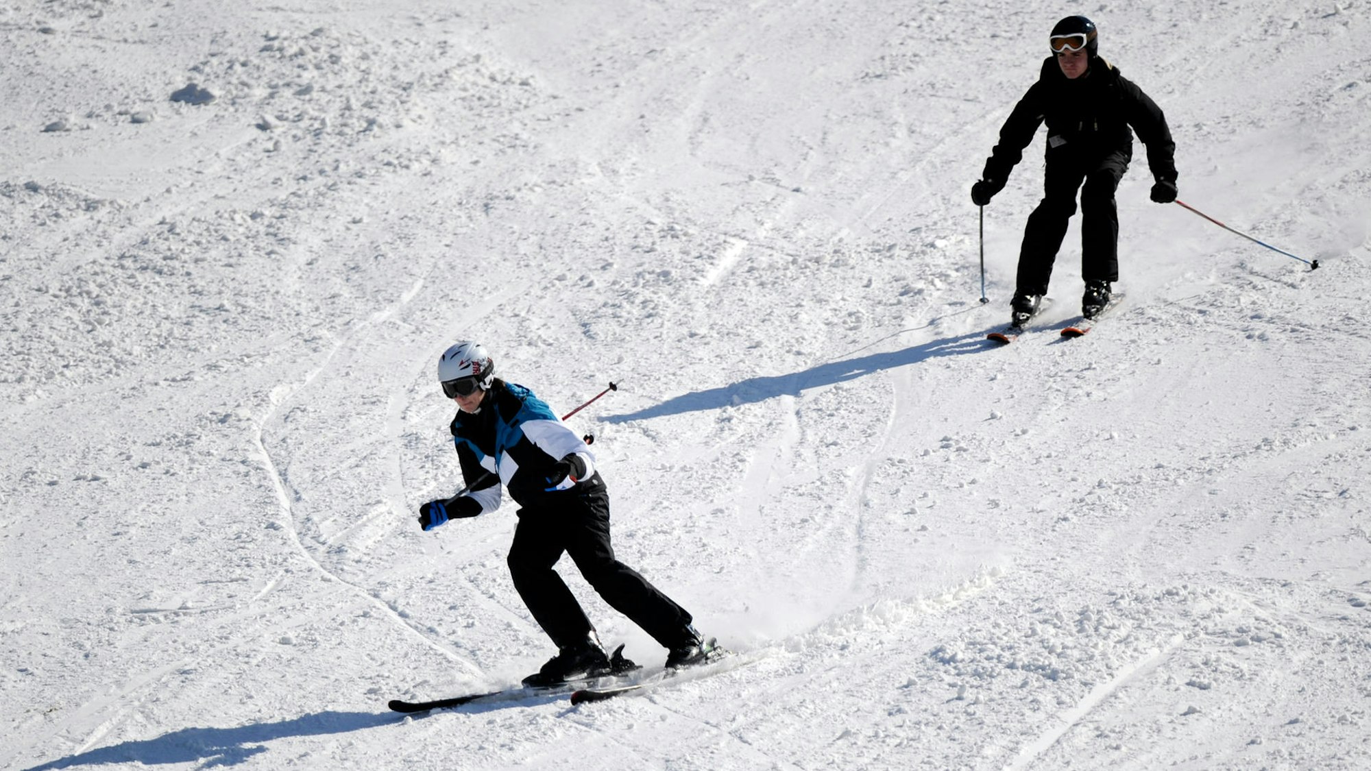 Zwei Skifahrer fahren eine Abfahrt hinunter
