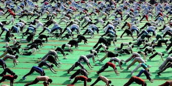 Menschen beim Massenyoga in Indien. Auch in Deutschland wird Yoga immer beliebter.
