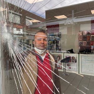 Durch das schwer beschädigte Schaufenster seines Ladens blickt Corc Sener, der schon häufig Opfer von Räubern war.