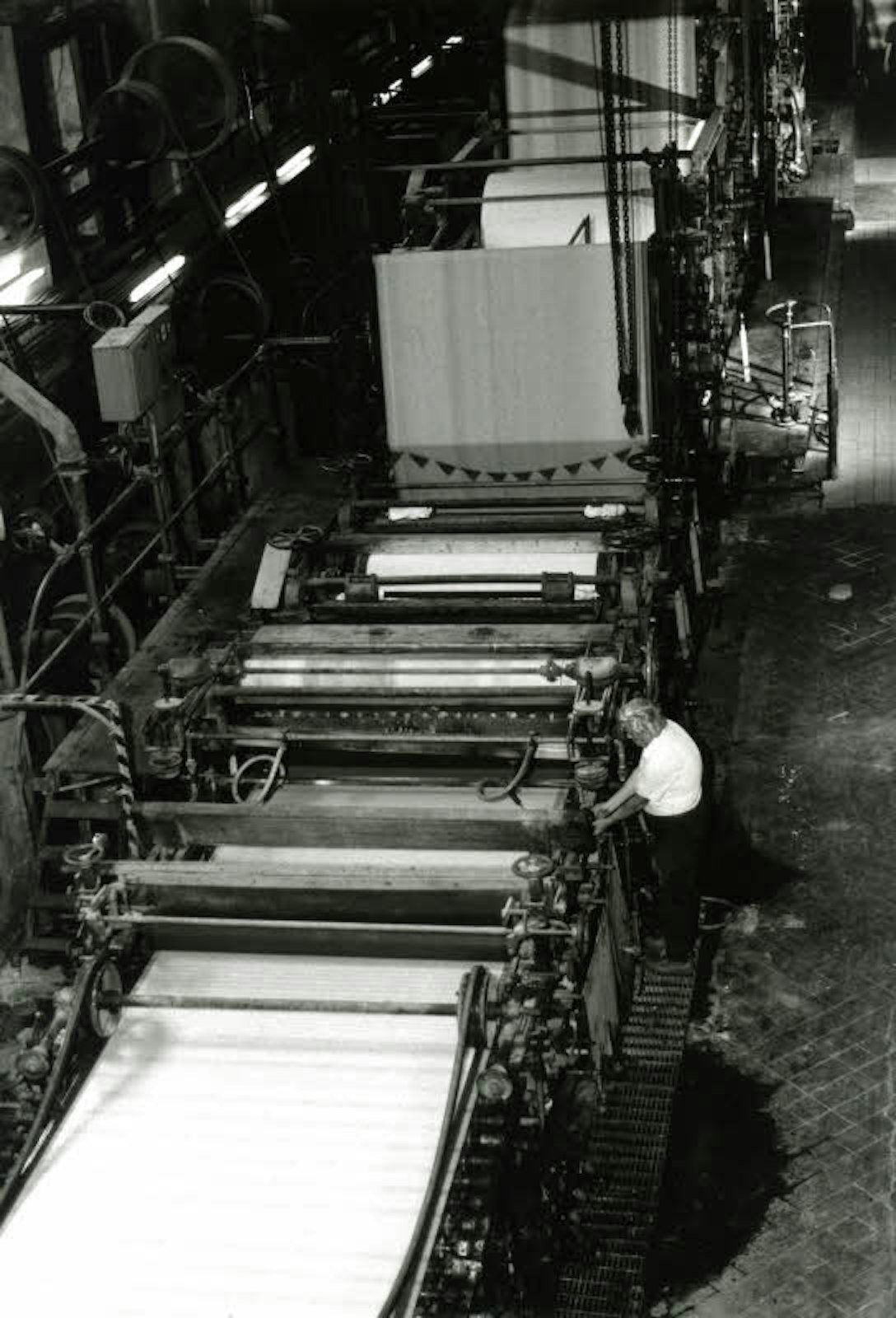 Ein Arbeiter an der Papiermaschine PM 4, die heute im Industriemuseum Alte Dombach zu sehen ist.