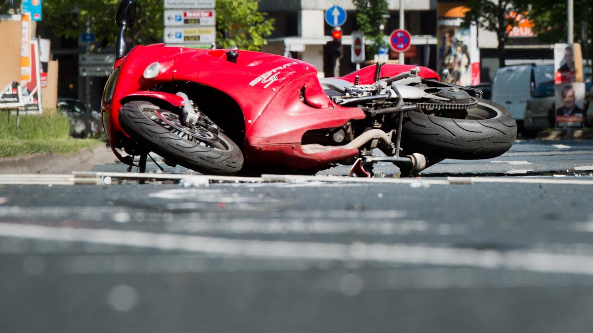 Köln. Ein rotes Motorrad liegt nach einem Unfall auf dem Boden.
